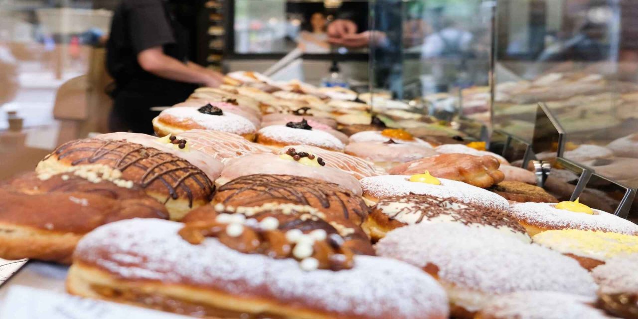 angled picture of various donuts in glass store case