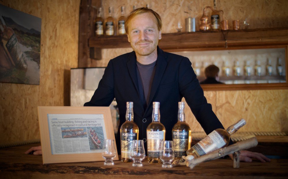 man standing with whiskey bottles