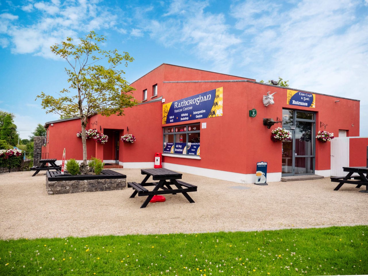 red building with benches outside in front of grass